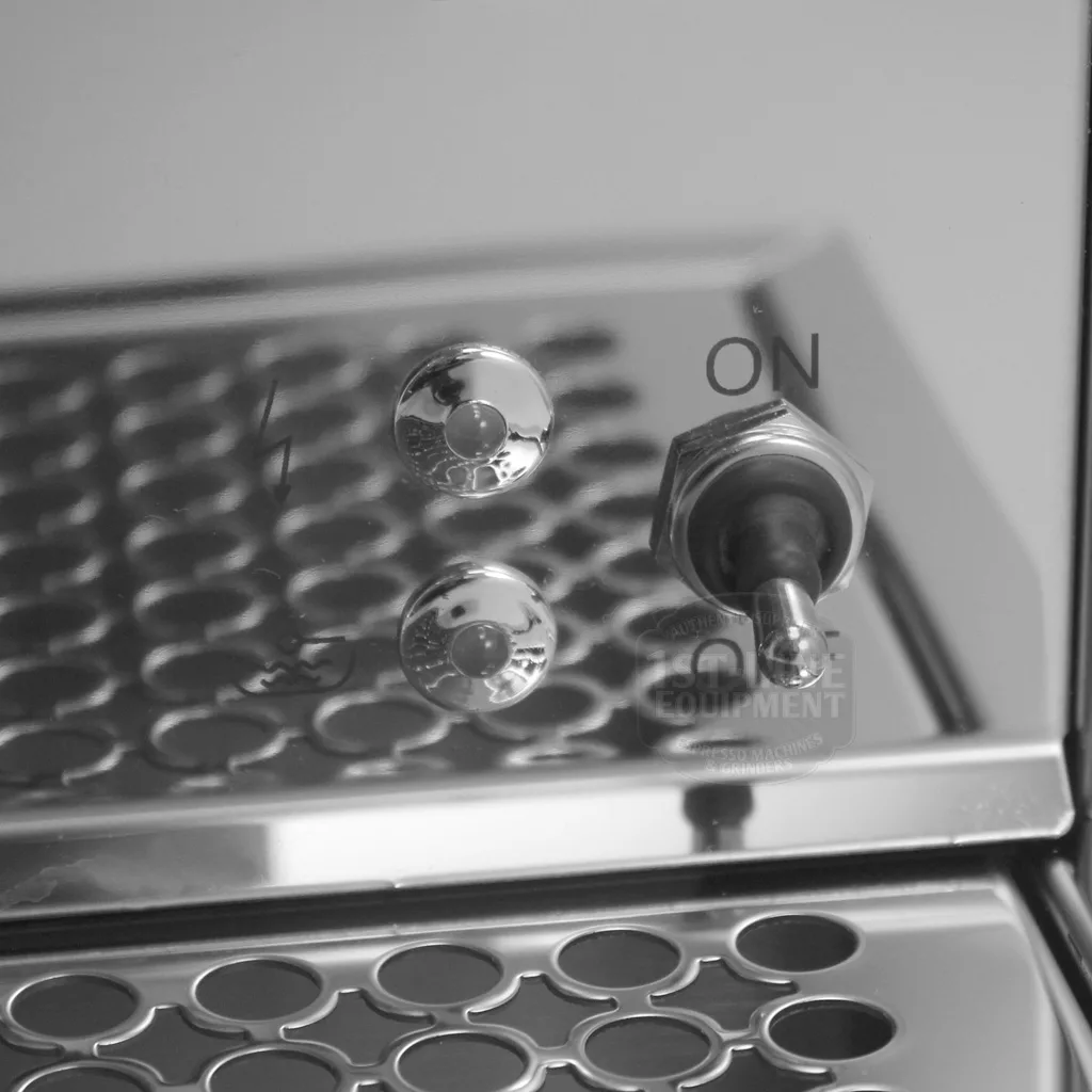 A close-up of the DISCONTINUED Bezzera BZ07 PM PID Espresso Machine’s metallic switch in the ON position, with two round buttons and a perforated metal surface in black and white, their reflections visible on the shiny exterior. © 2025 1st-line.com
