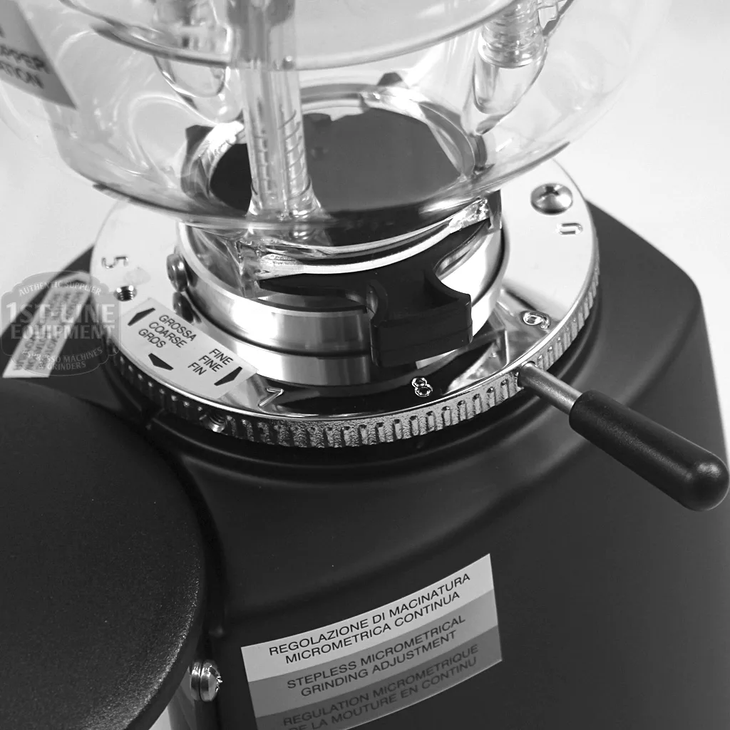 Close-up of the REDIRECTED Mazzer Mini Commercial Espresso Coffee Grinder in black with timer and doser, showing a clear hopper, labeled grind size adjustment dial, metal fine-tuning lever, and visible instructions on the side. © 2025 1st-line.com
